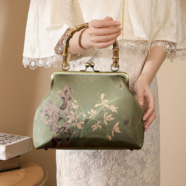 Bolso cruzado con asa de bambú y cadena de metal, piedras de Buda, plantas verdes, montañas