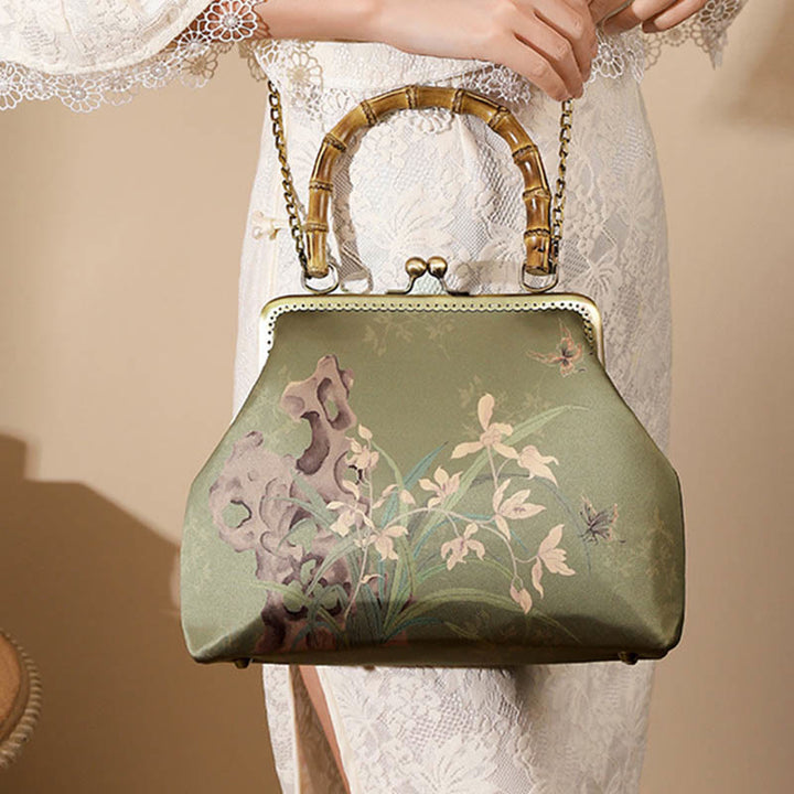 Bolso cruzado con asa de bambú y cadena de metal, piedras de Buda, plantas verdes, montañas