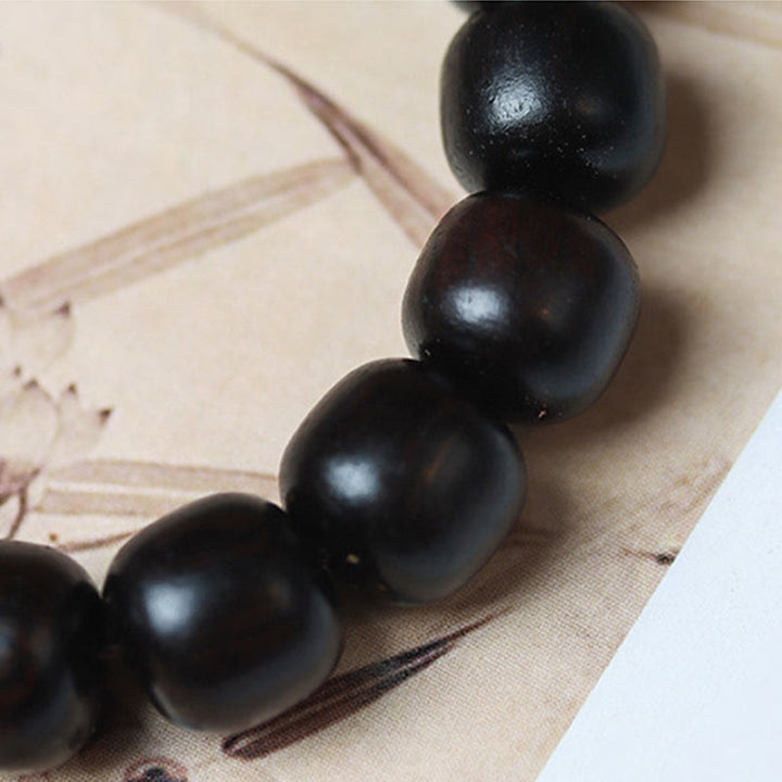 Pulsera de calma grabada en madera de ébano con nubes auspiciosas y Buddha Stones