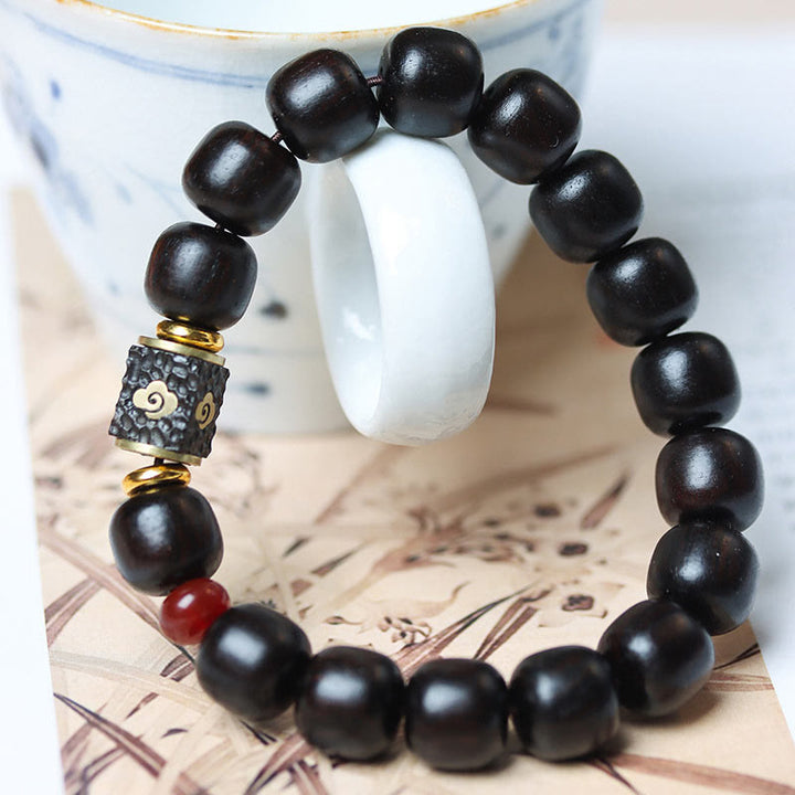 Pulsera de calma grabada en madera de ébano con nubes auspiciosas y Buddha Stones