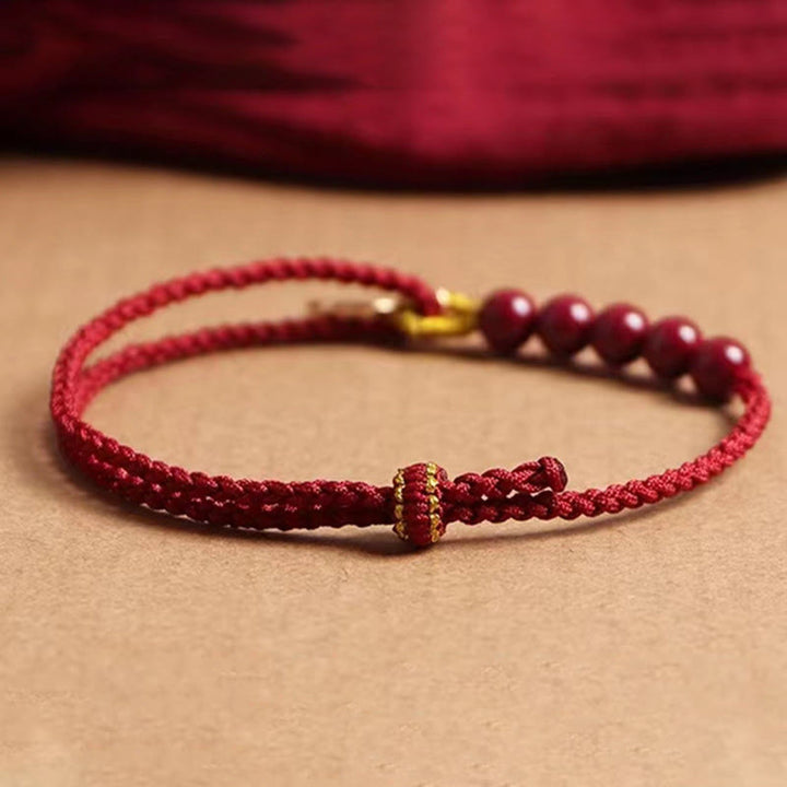 Pulsera trenzada hecha a mano con hilo rojo y cuentas de cinabrio con carácter Fu y Buddha Stones