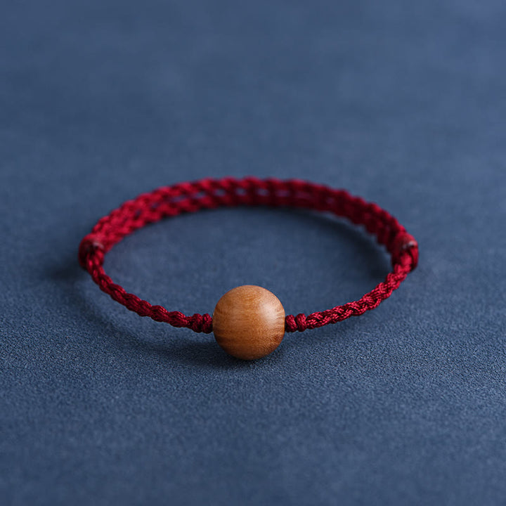 Pulsera trenzada con cuentas de madera de melocotón natural y Buddha Stones que alejan a los malos espíritus
