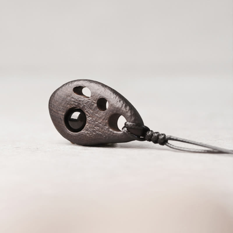 Collar con colgante de obsidiana hueca con incrustaciones de madera de ébano y Buddha Stones que transmiten paz y calma