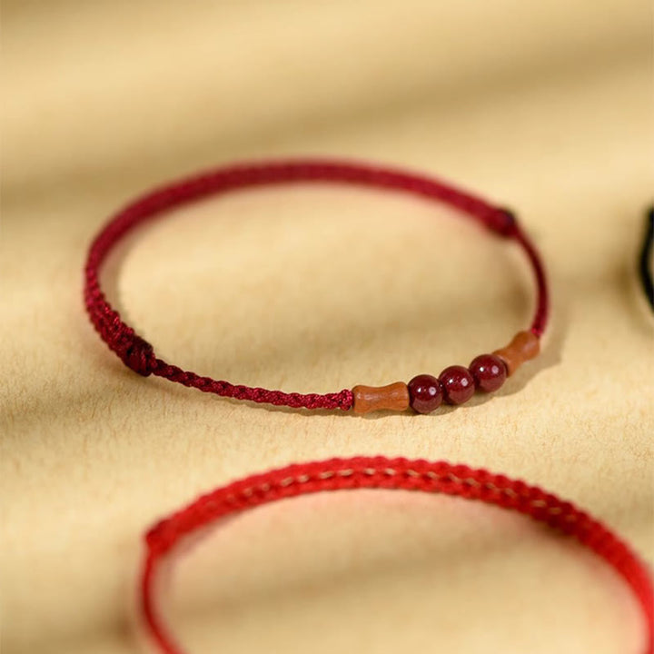 Pulsera de hilo bendecido de madera de melocotón con cuentas de cinabrio y Buddha Stones