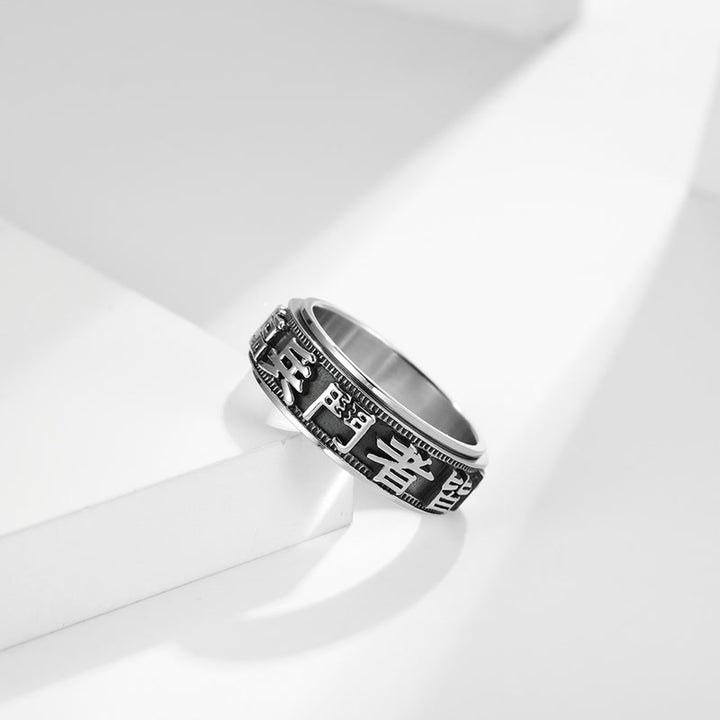 Anillo giratorio de acero titanio con letras en equilibrio y calma