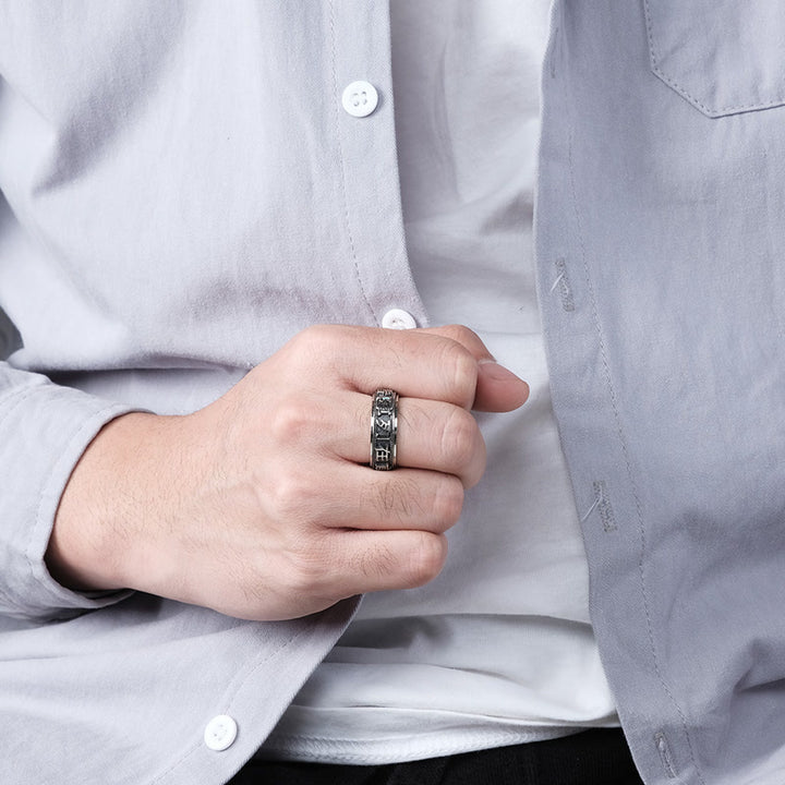 Anillo giratorio de acero titanio con letras en equilibrio y calma