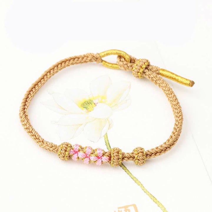 Pulsera de cuerda trenzada de ocho hebras de la suerte con tres flores de melocotón hechas a mano con Buddha Stones