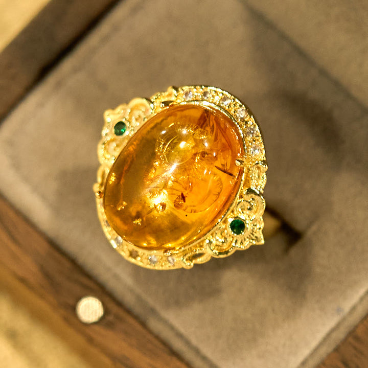 Anillo de enfoque con diseño de huevo de paloma y flor de ámbar con Buddha Stones