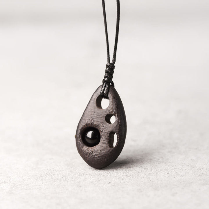 Collar con colgante de obsidiana hueca con incrustaciones de madera de ébano y Buddha Stones que transmiten paz y calma