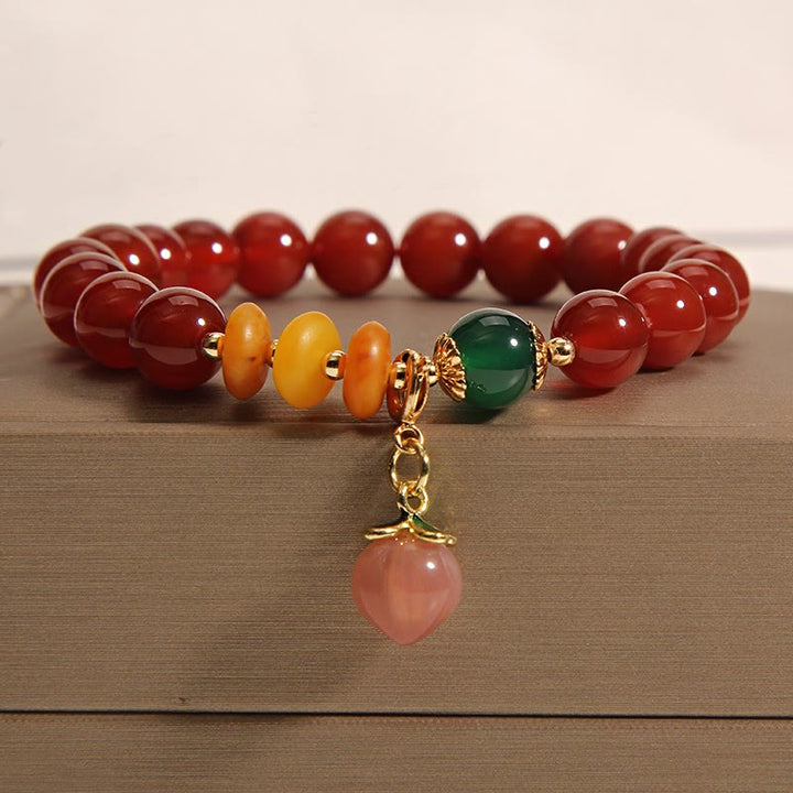 Pulsera de autoaceptación con dijes de melocotón, ámbar y ágata roja de Buddha Stones - image 1