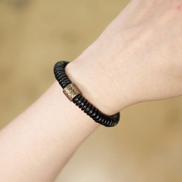 Pulsera de calma con Buddha Stones, madera de ébano, cobre y latón