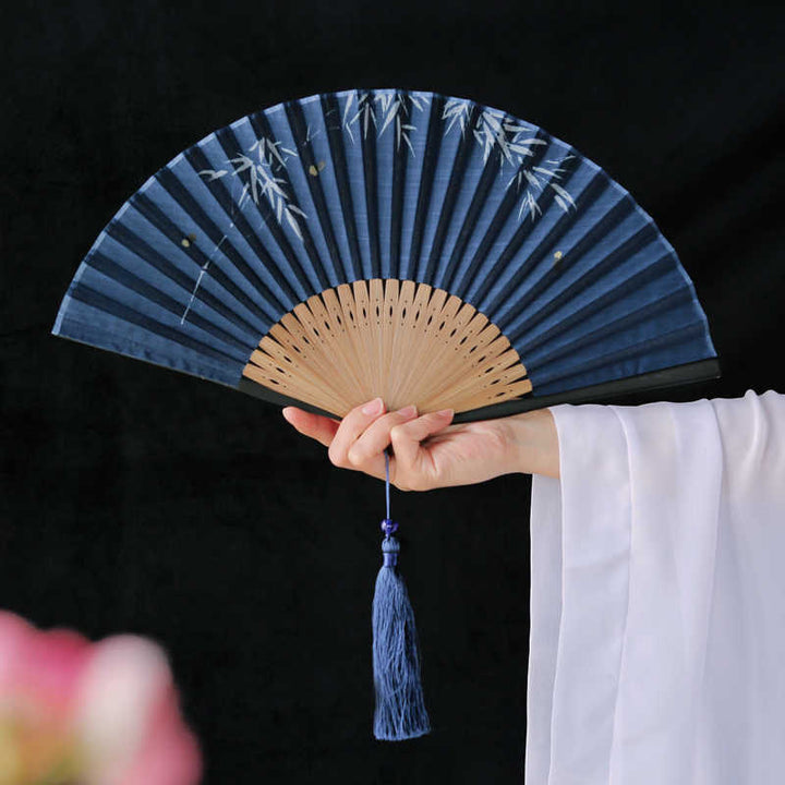 Abanico plegable de bambú con borlas y diseño de hojas de bambú y Buddha Stones