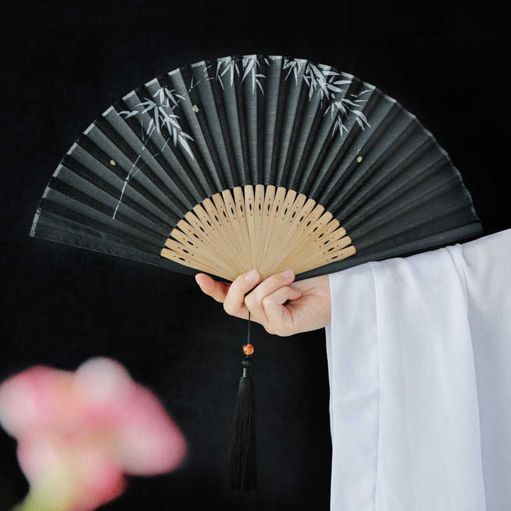 Abanico plegable de bambú con borlas y diseño de hojas de bambú y Buddha Stones