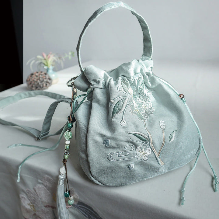 Bolso bandolera de lona con bordado de Buddha Stones, flores verdes y hojas.