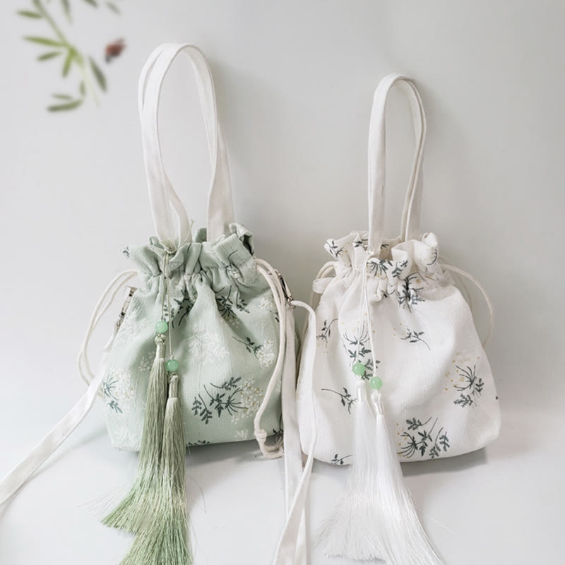 Bolso bandolera de lona con diseño de Buddha Stones, flores blancas y hojas verdes.