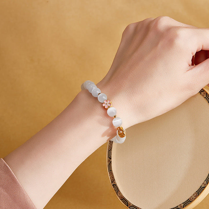 Pulsera con Buddha Stones en plata de ley 925 con flor de melocotón natural y ojo de gato blanco
