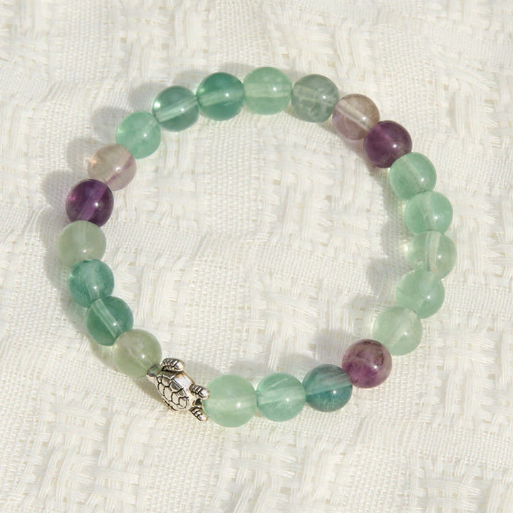Buddha Stones Pulsera de cuentas de fluorita multicolor con forma de tortuga, que ofrece claridad y protección. - image 1