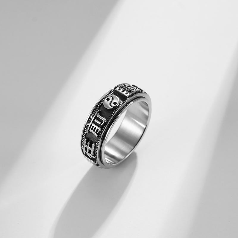 Anillo giratorio de acero titanio con letras en equilibrio y calma
