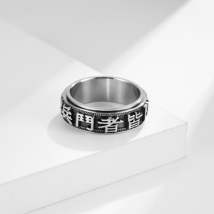 Anillo giratorio de acero titanio con letras en equilibrio y calma