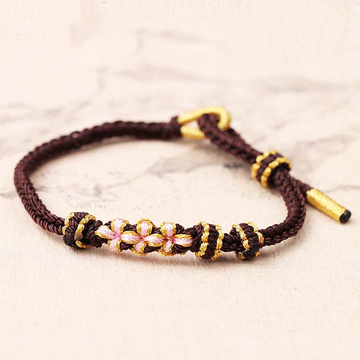 Pulsera de cuerda trenzada de ocho hebras de la suerte con tres flores de melocotón hechas a mano con Buddha Stones