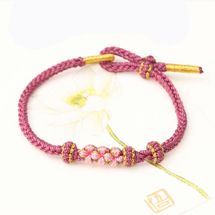 Pulsera de cuerda trenzada de ocho hebras de la suerte con tres flores de melocotón hechas a mano con Buddha Stones